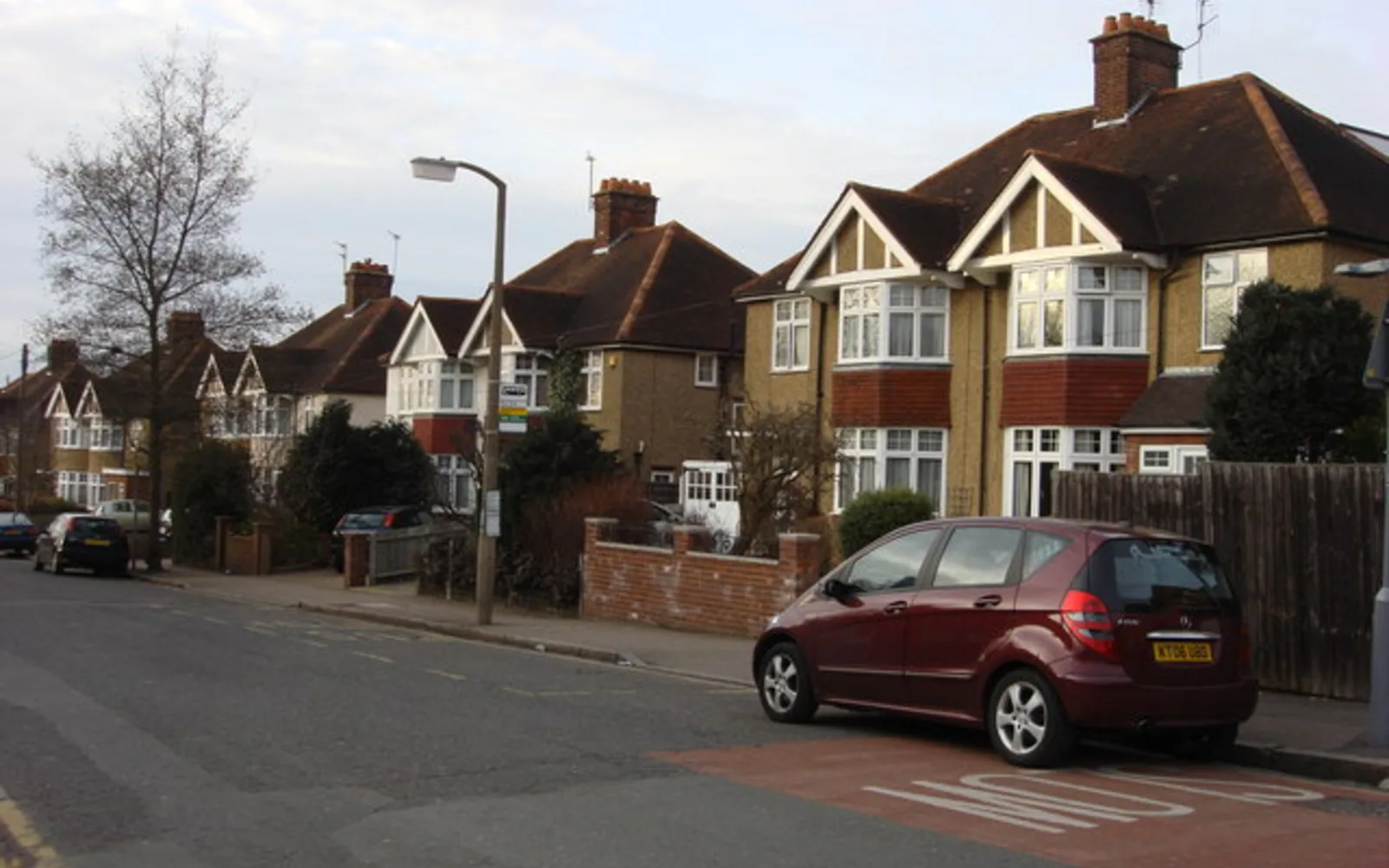 Row of traditional brick suburban houses with driveways and front yards